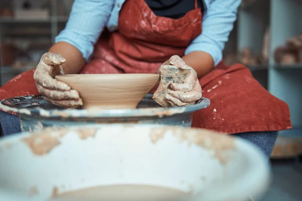 Potier féminin dans un bol en argile de polissage de tablier en atelier — Photo