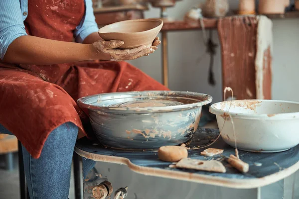 围裙中的女陶工拿着陶器碗 — 图库照片