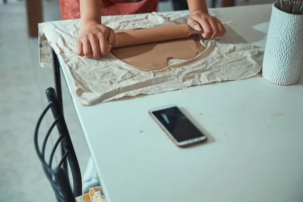 Vrouwelijke handen rollen polymeer klei in aardewerk workshop — Stockfoto