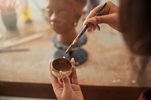 Female ceramic artist painting pottery in workshop — Stock Photo, Image