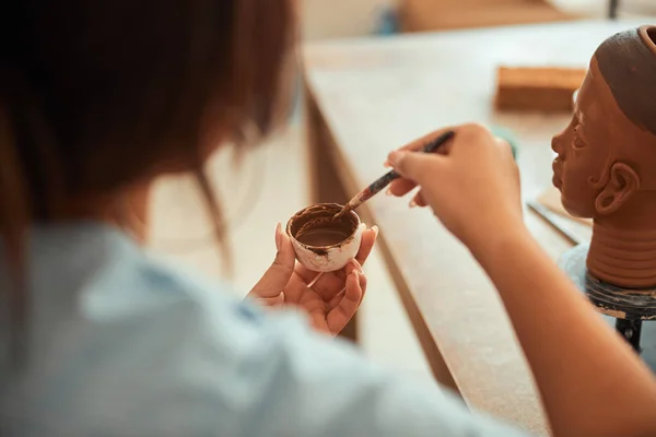 Jeune femme tenant pinceau et bol avec de la peinture brune — Photo