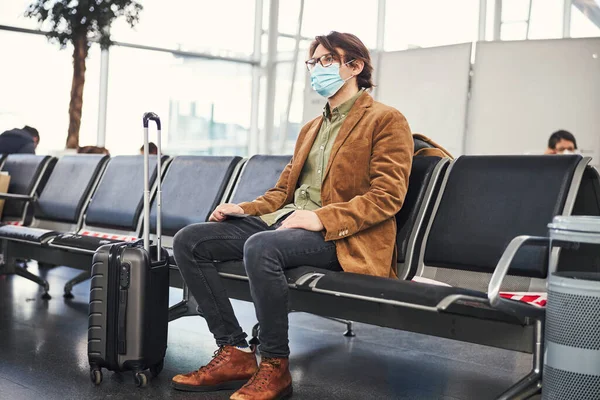 空港でのフライトを待っている医療マスクの若者 — ストック写真