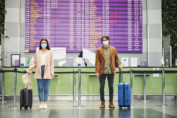 空港で安全な社会的距離を保つ若い男と女 — ストック写真