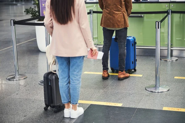 Joven hombre y mujer haciendo cola en el aeropuerto —  Fotos de Stock