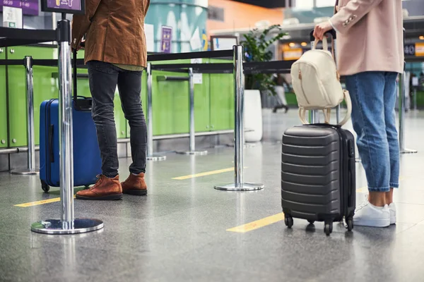 Joven hombre y mujer haciendo cola en el aeropuerto — Foto de Stock