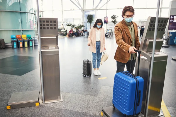 空港で手荷物検査機を使う若者 — ストック写真