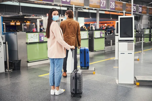 乗客が列に並び、空港で社会的距離を保つ — ストック写真