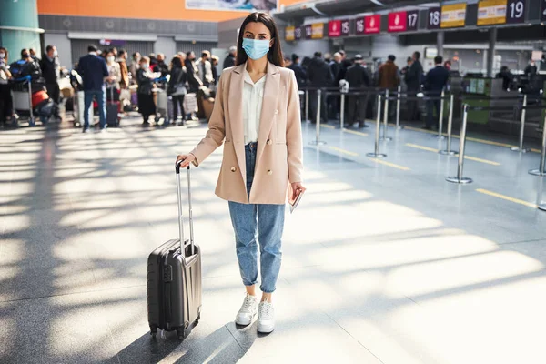 空港に立つ旅行スーツケースを持つエレガントな女性 — ストック写真