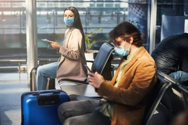 空港でのフライトを待っている医療マスクの乗客 — ストック写真
