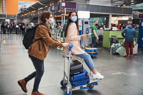 Lovely couple in medical masks having fun at airport