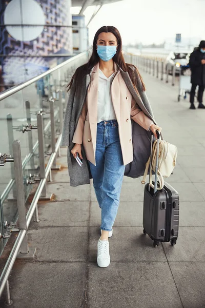 空港で屋外に立つ医療用マスクのエレガントな女性 — ストック写真