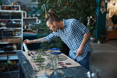 Sakallı erkek hippi atölyede bitki yetiştirdi.