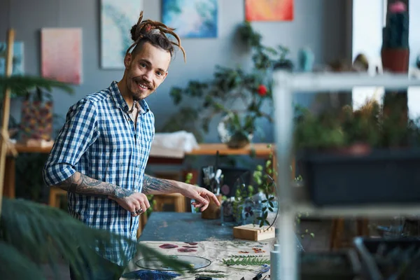 Vrolijke jongeman maakt herbarium in werkplaats — Stockfoto