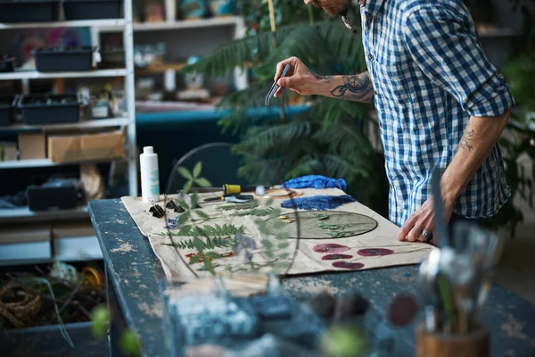 Jongeman in geruit hemd die thuis herbarium maakt — Stockfoto