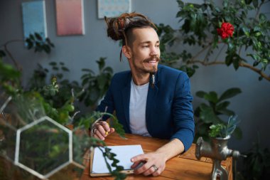 Memleketteki panoya yazan neşeli genç adam.
