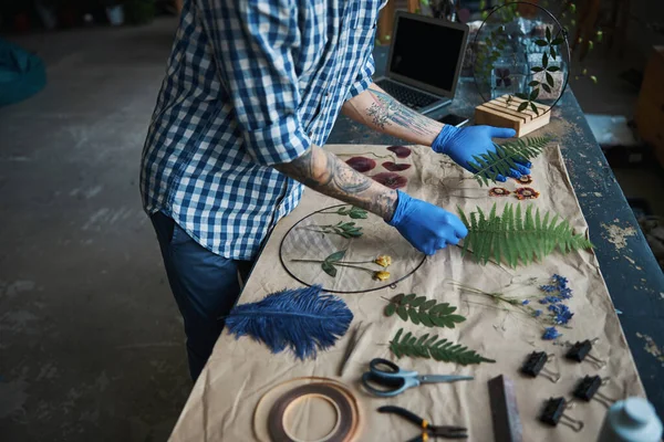 Man in steriele handschoenen die herbarium maken in de werkplaats — Stockfoto