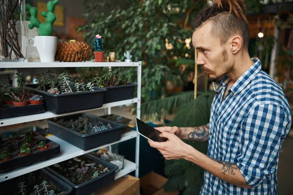 Knappe jongeman met behulp van digitale tablet computer thuis — Stockfoto