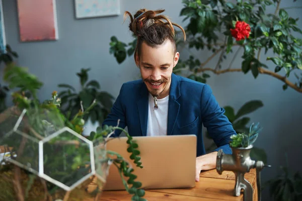 Fröhlicher junger Mann nutzt modernen Laptop zu Hause — Stockfoto