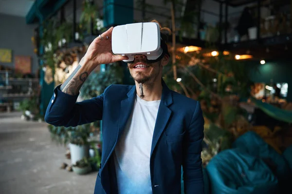 Fröhlicher junger Mann nutzt VR-Headset zu Hause — Stockfoto
