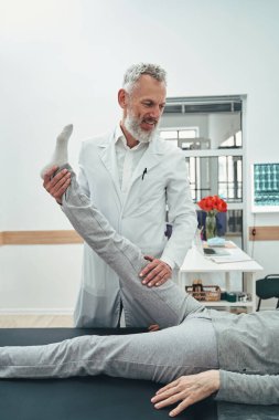 Omurgalı doktor bacak kaldırma testi yapıyor.