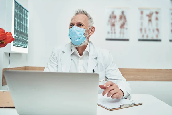 Dokter in een beschermend gezichtsmasker die patiënten ontvangt — Stockfoto