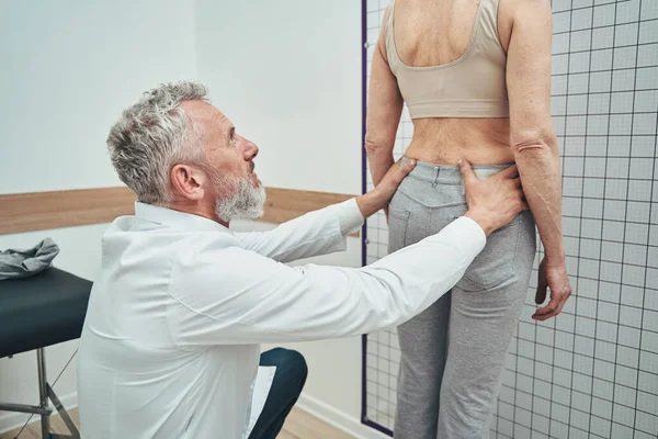 Fisiatra examinando uma coluna lombar de uma paciente do sexo feminino — Fotografia de Stock