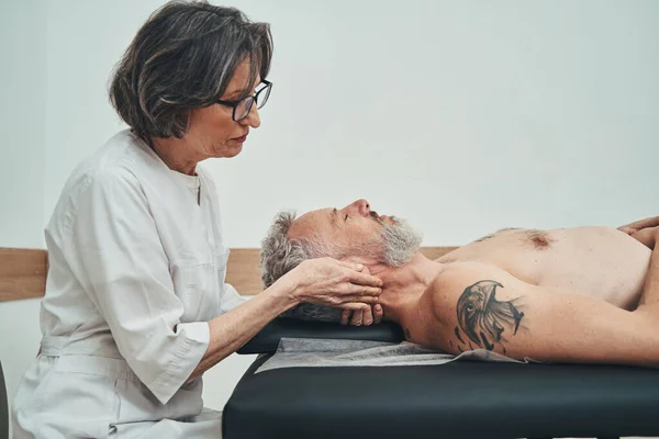 Médica focada conduzindo o tratamento manipulador osteopático — Fotografia de Stock