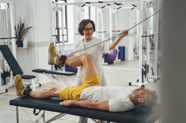 Bir fizikçinin yardımıyla diz esnetme ameliyatı yapan bir adam.