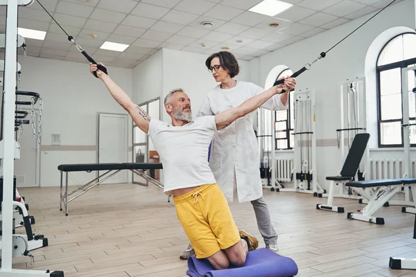 Sportivo che esegue un esercizio di stretching utilizzando una macchina via cavo — Foto Stock