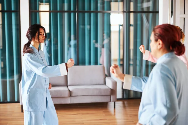 Pessoas fazendo movimentos simultâneos na prática do qigong — Fotografia de Stock