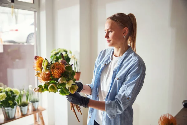 Dama pensativa sosteniendo un arreglo floral de primavera en sus manos — Foto de Stock