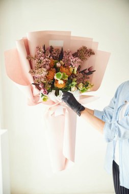 Elinde güzel bir buket çiçek tutan profesyonel bir çiçekçi.