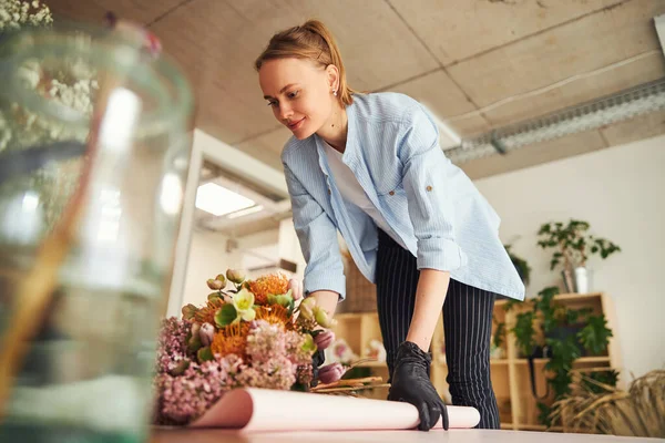 Vrouwelijke bloemist leunend over een mooi boeket — Stockfoto