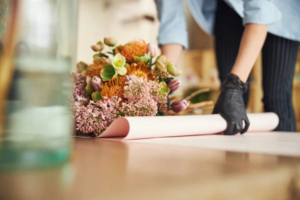 Mujer con guantes de nitrilo trabajando en un arreglo floral de primavera — Foto de Stock