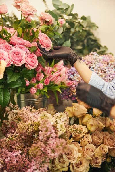 Doświadczona kobieta kwiaciarnia badająca roślinę ozdobną — Zdjęcie stockowe