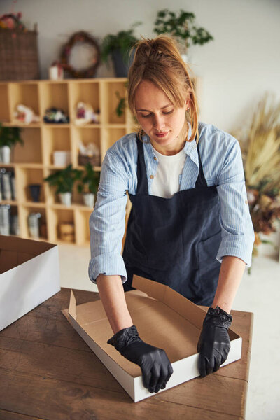 Фокусированный флорист устанавливает картонную коробку