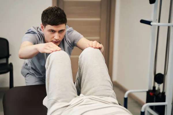 Terapeuta determinato abbassare le gambe della persona sul divano medico — Foto Stock