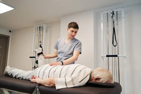 Senior male lying on stomach while working out his leg — Stock Photo, Image