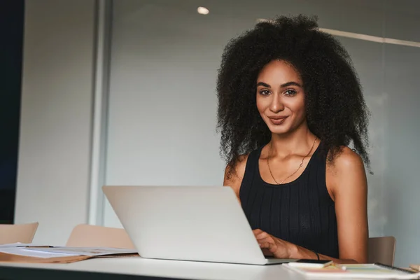 Attraktiv dam ser nöjd ut på sin arbetsplats — Stockfoto