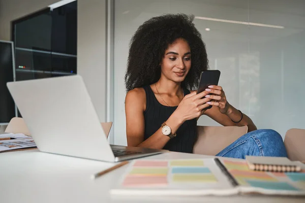 Lugn kontorsarbetare med sin smartphone och leende — Stockfoto