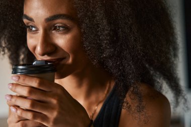 Kahve aşığı en sevdiği içeceği içiyor ve gülümsüyor.