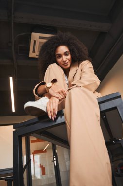 Güzel bayan masada oturuyor ve aşağıya bakıyor.