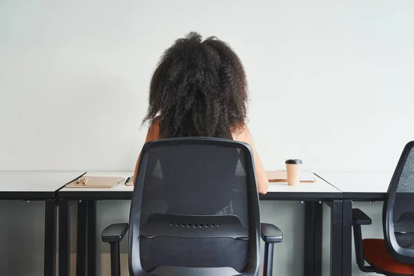 Zeldzaam uitzicht op de vrouw die aan tafel werkt — Stockfoto