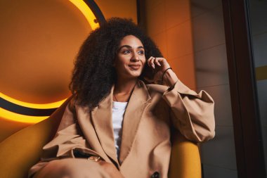 Neşeli güzel bayan yalnız ve mutlu bir şekilde gülümsüyor.