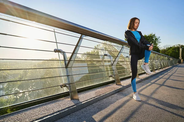 Jovem apto feminino exercitando antes de treinar ao ar livre — Fotografia de Stock