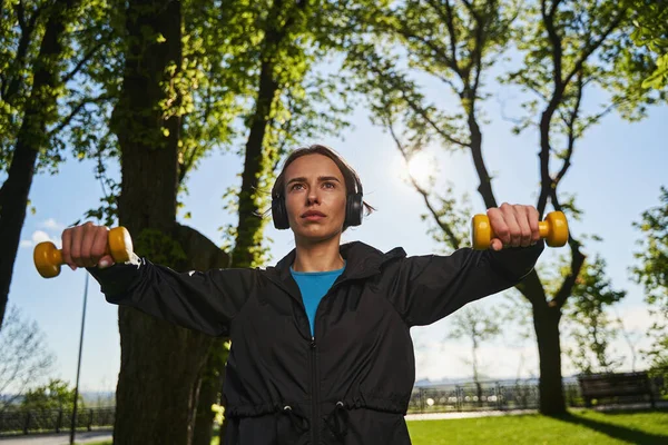 Mulher motivada fazendo exercícios no peito ao ar livre — Fotografia de Stock