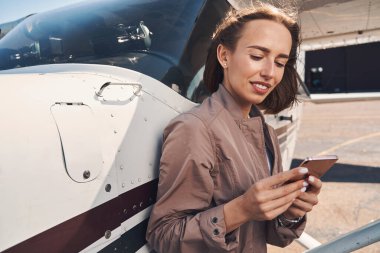 Havaalanında cep telefonu kullanan güzel bir genç kadın.