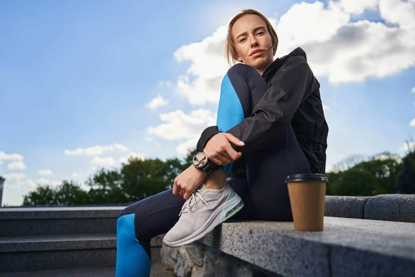 Sereno mulher desportiva relaxante com café ao ar livre — Fotografia de Stock