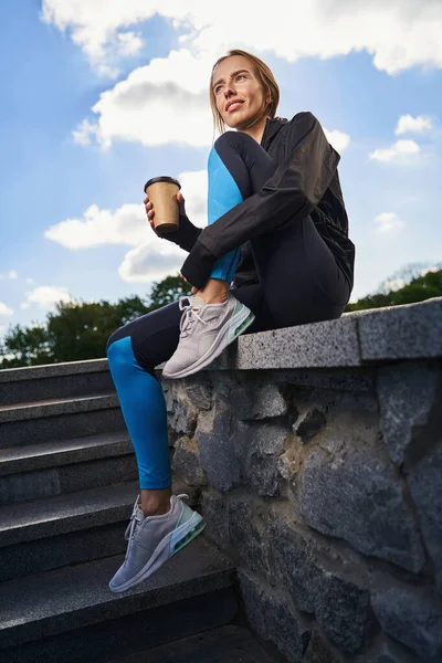 Desportista sorridente com xícara de café ao ar livre — Fotografia de Stock