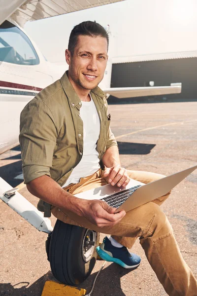 Junger Mann benutzt Notebook im Freien auf Flugplatz — Stockfoto